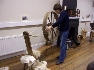 Mary B. Davitt giving a wool spinning demonstration using her grandmother's big wheel | Mary O'Malley